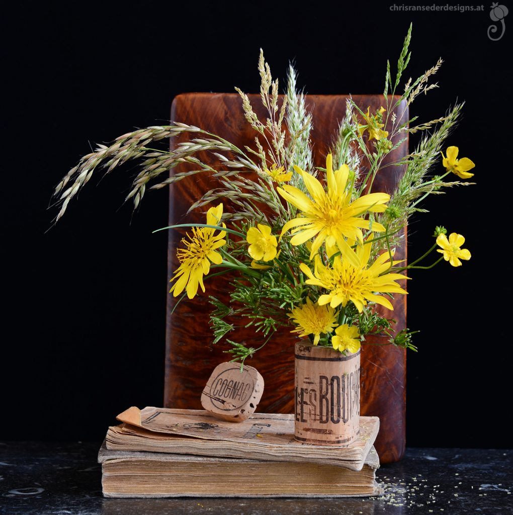 A cork stopper, hollowed out and filled with yellow flowers and grasses.| Ein Korken, ausgehöhlt und gefüllt mit gelben Blumen. 